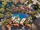 Aerial view of a resort-style pool area featuring palm trees, lounge chairs, and beautiful landscaping at 12521 Floridays Resort Dr # 307F, Orlando, FL 32821