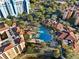 Aerial view showcasing a large, uniquely shaped resort-style pool surrounded by lush landscaping and palm trees at 12521 Floridays Resort Dr # 307F, Orlando, FL 32821