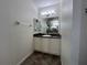 Well-lit bathroom featuring a vanity with storage cabinets and a decorative mirror at 1368 Del Mar Dr, Kissimmee, FL 34759