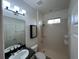 Bathroom with shower, tiled walls, single sink and tile floors at 1368 Del Mar Dr, Kissimmee, FL 34759