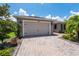 Inviting single-story home featuring a two-car garage, paved driveway, and mature landscaping at 1368 Del Mar Dr, Kissimmee, FL 34759