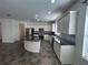 Modern kitchen featuring white cabinetry, granite countertops, and stainless steel appliances at 1368 Del Mar Dr, Kissimmee, FL 34759