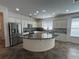 Well-lit kitchen with stainless steel appliances, island, and white cabinets at 1368 Del Mar Dr, Kissimmee, FL 34759