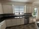 Bright kitchen featuring a stainless steel sink, granite countertops, white cabinets and mosaic tile backsplash at 1368 Del Mar Dr, Kissimmee, FL 34759