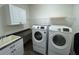 Functional laundry room with sink, countertop, overhead cabinet, and newer Samsung washer and dryer at 1368 Del Mar Dr, Kissimmee, FL 34759