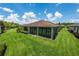 Exterior view of a single-story home featuring a well-kept lawn and a partially screened lanai at 1368 Del Mar Dr, Kissimmee, FL 34759
