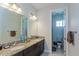 Well-lit bathroom with double sinks, granite countertop, and adjacent toilet room at 15724 Cutter Sail Pl, Winter Garden, FL 34787