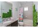Bathroom with modern vanity, colorful shower curtain, and decorative greenery at 15724 Cutter Sail Pl, Winter Garden, FL 34787