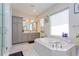 Spa-like bathroom with a soaking tub, gray cabinets, and a glass enclosed shower at 15724 Cutter Sail Pl, Winter Garden, FL 34787