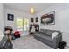 Bedroom featuring a gray sofa, carpet, and a window with natural light at 15724 Cutter Sail Pl, Winter Garden, FL 34787