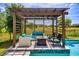 The pergola has comfortable seating and a stylish fire pit overlooking the pool at 15724 Cutter Sail Pl, Winter Garden, FL 34787