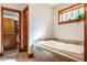 Bathroom featuring a large soaking tub with tile surround and wood-trimmed window at 1612 E Washington St, Orlando, FL 32803