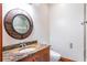 Bathroom features a granite countertop with an oval sink, a round mirror, and modern fixtures at 1612 E Washington St, Orlando, FL 32803