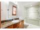 Bathroom features granite countertops, a rectangular mirror and a walk-in shower with white tiled walls at 1612 E Washington St, Orlando, FL 32803