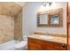 Bathroom features a tub-shower combo, stylish tile, granite countertop and decorative mirror at 1612 E Washington St, Orlando, FL 32803