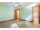 Well-lit bedroom features hardwood floors, a ceiling fan, and an adjacent bathroom with walk-in shower at 1612 E Washington St, Orlando, FL 32803