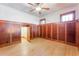 Bedroom featuring wood paneling, hardwood floors, ceiling fan, and secret door at 1612 E Washington St, Orlando, FL 32803