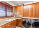 The laundry room features wood cabinetry, granite countertops, a sink, and a stainless steel washer and dryer at 1612 E Washington St, Orlando, FL 32803