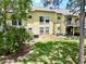 View of backyard of the condo building, featuring lush green grass and trees providing shade at 2040 Royal Bay Blvd # 30, Kissimmee, FL 34746
