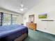 Large main bedroom with a fan, TV, dresser, and access to the balcony at 2040 Royal Bay Blvd # 30, Kissimmee, FL 34746
