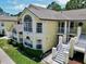 Charming yellow condo with large windows, white trim, and well-maintained landscaping in a community setting at 2040 Royal Bay Blvd # 30, Kissimmee, FL 34746