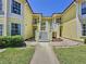 Inviting yellow townhouse with white trim and a well-manicured lawn, perfect for comfortable living at 2040 Royal Bay Blvd # 30, Kissimmee, FL 34746