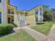 A charming yellow condo featuring bright stairs, trim, landscaped lawn, walkway and attractive windows at 2040 Royal Bay Blvd # 30, Kissimmee, FL 34746