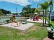 A full view of the playground with swings, slides and other equipment, situated in a grassy, tropical area at 2040 Royal Bay Blvd # 30, Kissimmee, FL 34746