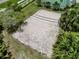 An aerial view of an outdoor sand volleyball court bordered by palm trees, lush grass, and other vegetation at 2040 Royal Bay Blvd # 30, Kissimmee, FL 34746