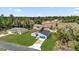 Aerial view of a home with a blue garage door, a gray roof, and a long driveway at 2415 Sw 165Th Pl, Ocala, FL 34473