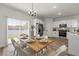 Bright dining area featuring a modern chandelier and a view of the backyard through sliding doors at 2415 Sw 165Th Pl, Ocala, FL 34473