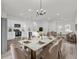 Elegant dining area flowing into the living room and featuring a modern chandelier and marble table at 2415 Sw 165Th Pl, Ocala, FL 34473