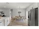 Bright dining room showcasing modern chandelier, table setting, and stainless steel refrigerator at 2415 Sw 165Th Pl, Ocala, FL 34473