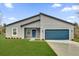 Charming single story home with gray stucco, blue front door, and well-manicured lawn at 2415 Sw 165Th Pl, Ocala, FL 34473