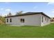 Home exterior featuring a sliding glass door leading to a patio and a well-maintained lawn at 2415 Sw 165Th Pl, Ocala, FL 34473