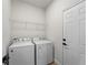 Bright laundry room with washer, dryer, and wire shelving at 2415 Sw 165Th Pl, Ocala, FL 34473