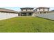 Large backyard with green grass and a vinyl fence, with a covered patio at 2546 Empress Dr, Kissimmee, FL 34741