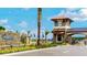 Community entrance featuring stone monument, tower, and professional landscaping with a blue sky and clouds background at 2546 Empress Dr, Kissimmee, FL 34741