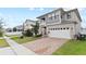 Charming two-story home showcasing modern architecture, a two-car garage, and brick paved driveway at 2546 Empress Dr, Kissimmee, FL 34741