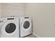 Bright laundry room featuring a Whirlpool washer and dryer with wire shelving at 2546 Empress Dr, Kissimmee, FL 34741