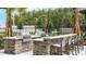 Outdoor kitchen featuring built-in stainless steel grill, stone counter, and bar stool seating at 2546 Empress Dr, Kissimmee, FL 34741