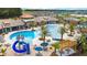 Community pool and clubhouse featuring a slide, covered seating, lounge chairs, and palm tree landscaping at 2546 Empress Dr, Kissimmee, FL 34741