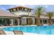 Community pool area with palm trees, lounge chairs, umbrellas, and views of the clubhouse at 2546 Empress Dr, Kissimmee, FL 34741