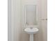 Elegant powder room featuring a pedestal sink, modern mirror, and neutral wall color at 2546 Empress Dr, Kissimmee, FL 34741