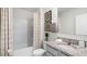 The bathroom has a modern vanity with granite countertop, a tiled shower with shower curtain, and white walls at 2610 Grandbury Grove Rd, Lakeland, FL 33811