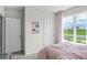 The bright bedroom includes two closets, neutral walls, light carpet, and a view of the outdoors at 2610 Grandbury Grove Rd, Lakeland, FL 33811