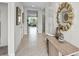 Bright hallway with tiled floors, neutral paint, and decorative mirror, leading to living areas at 2610 Grandbury Grove Rd, Lakeland, FL 33811