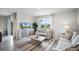 Bright living room with neutral sofas, a patterned rug, and a window with backyard views at 2610 Grandbury Grove Rd, Lakeland, FL 33811