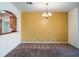 Dining area featuring neutral carpet and a contemporary chandelier, adjacent to the kitchen at 27307 Pine Straw Rd, Leesburg, FL 34748