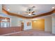 Large living room with a ceiling fan, carpet, and an open view to the dining area and kitchen at 27307 Pine Straw Rd, Leesburg, FL 34748